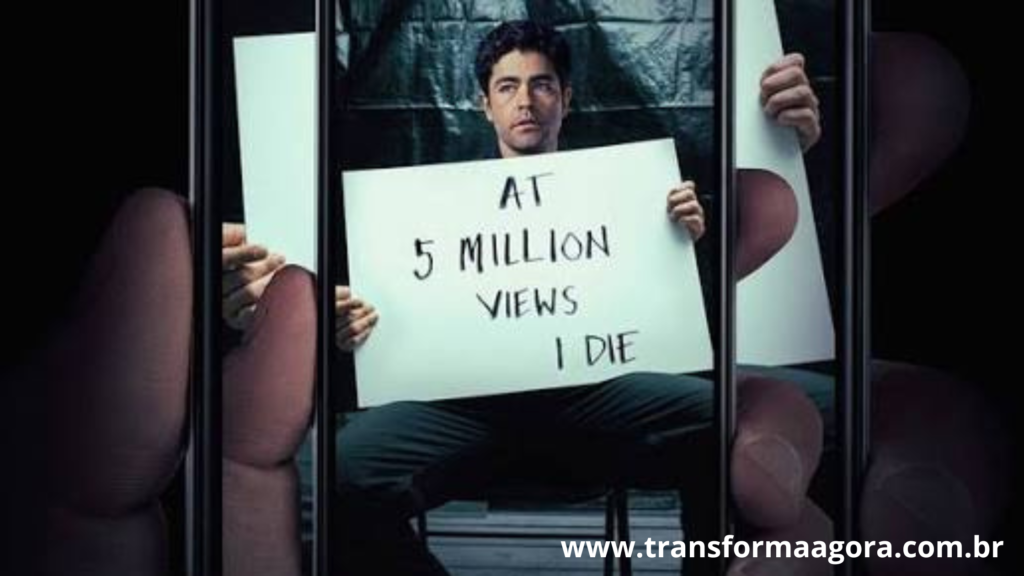 Um homem sentado segurando um cartas escrito: At 5 Milliom Views I Die.